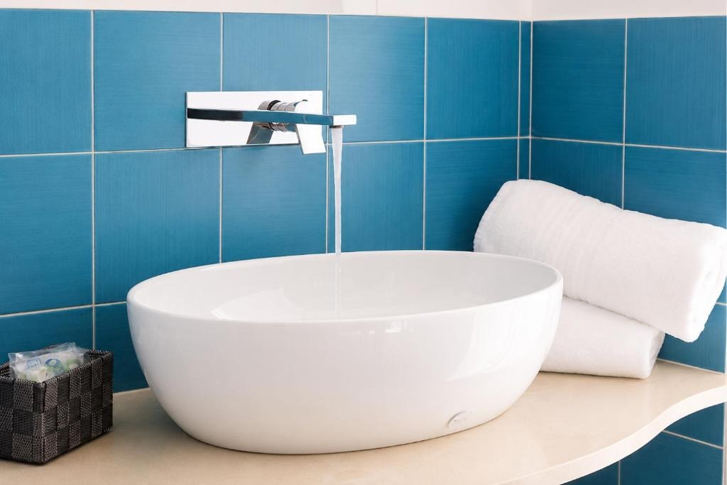 Modern vessel sink against turquoise tiles