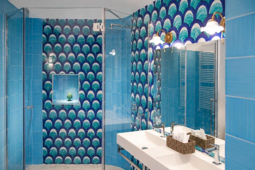 Shower wrapped in scale-patterned turquoise tiles