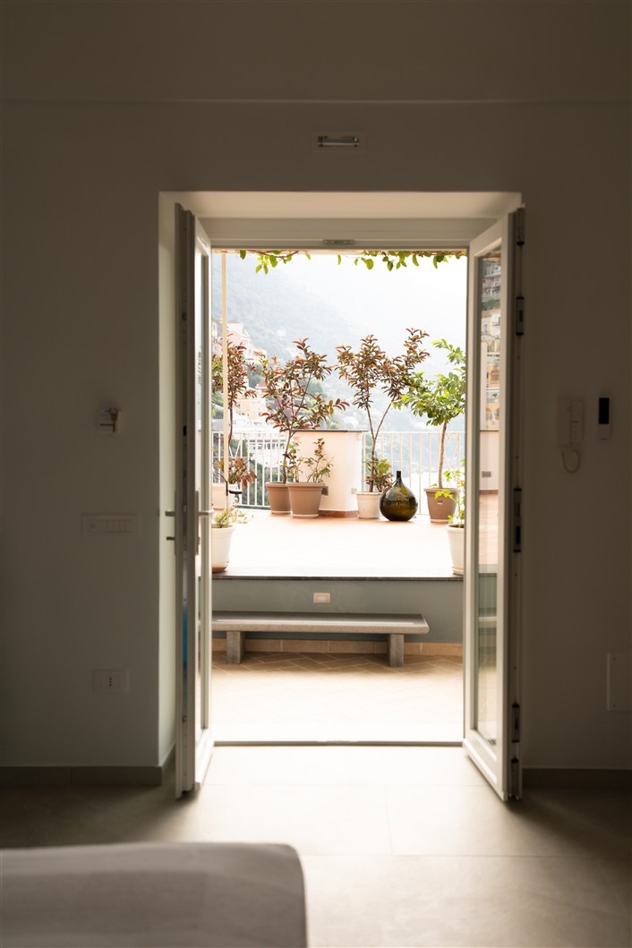 Open bedroom doors framing the sunlit terrace