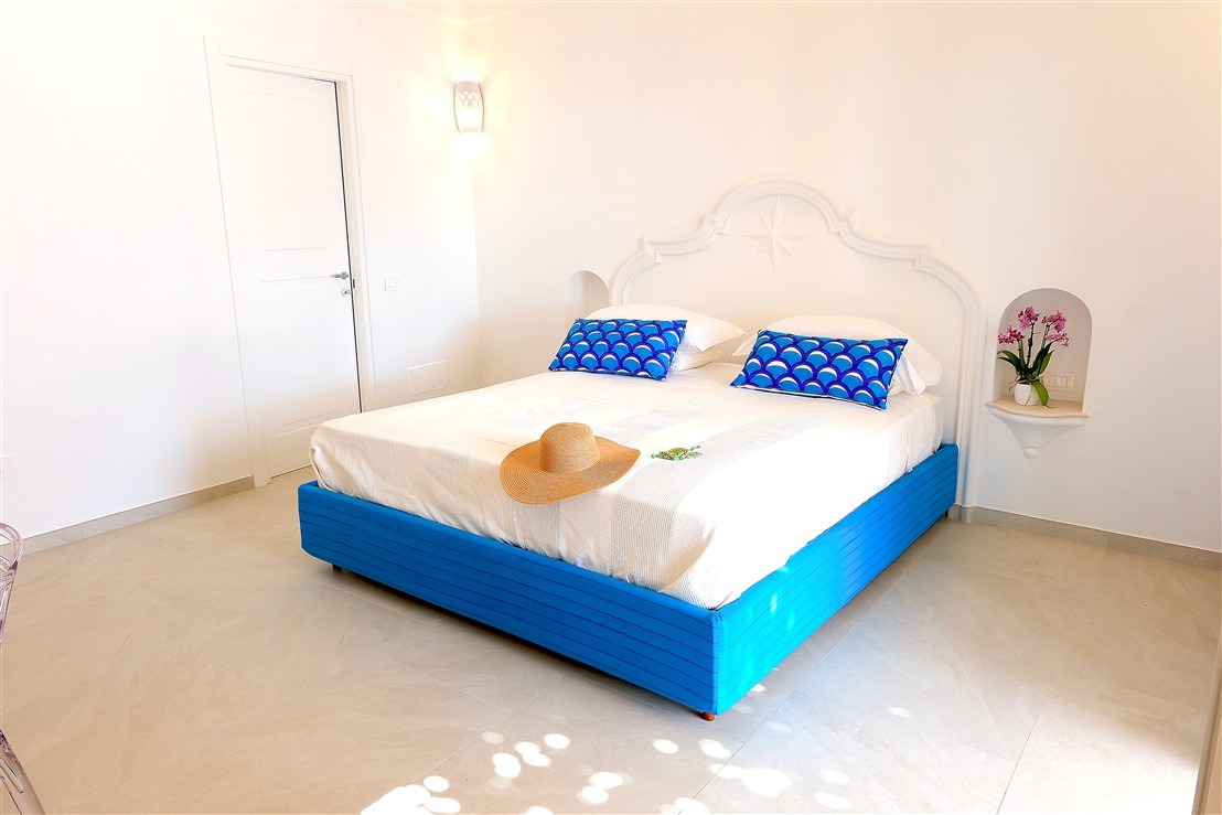 Bright double bedroom with blue accents and Mediterranean light